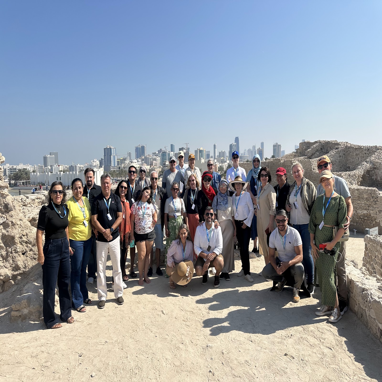 Grupo Rigue no Forte do Bahrein com skyline de Manama ao fundo