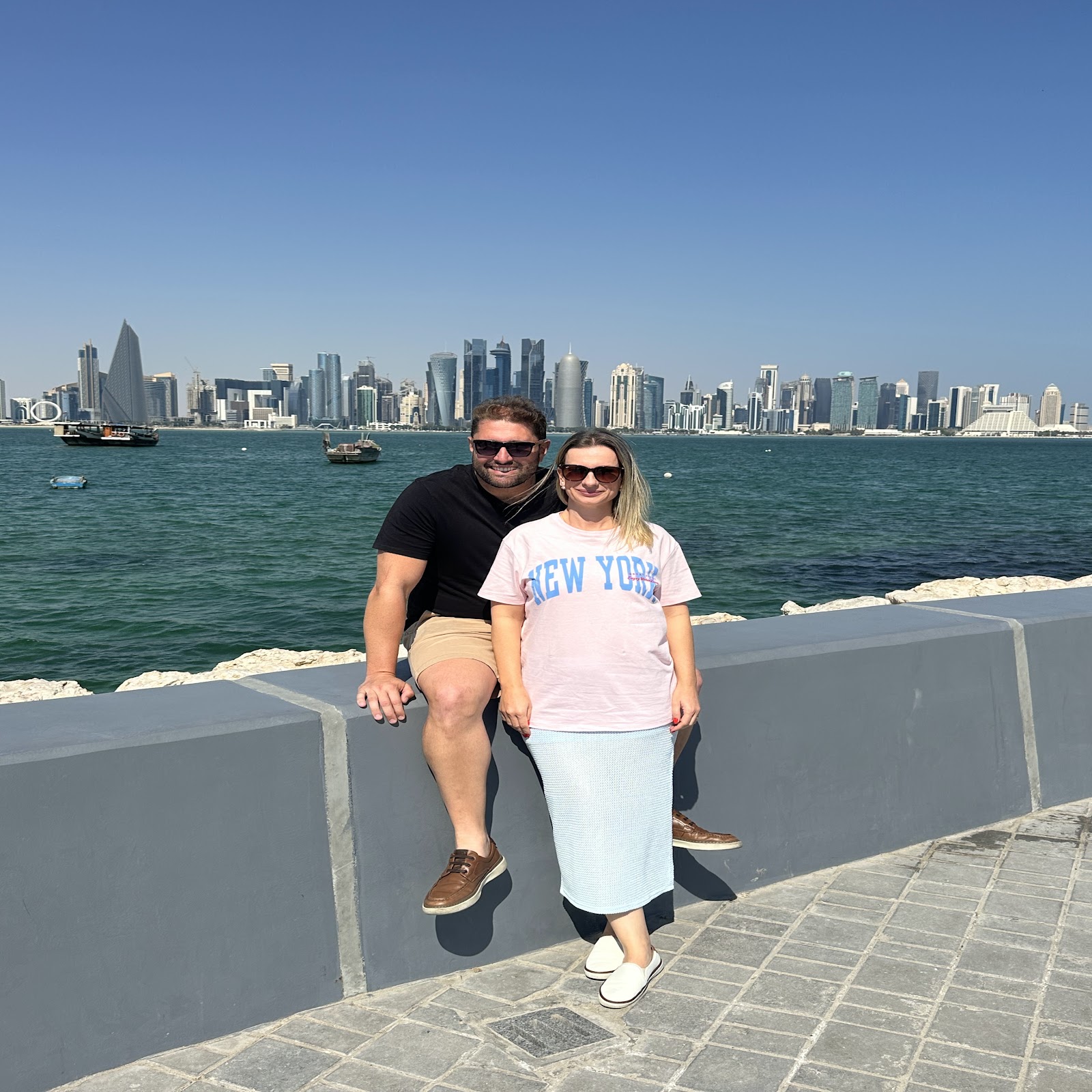 Viajantes da Rigue com skyline de Doha ao fundo