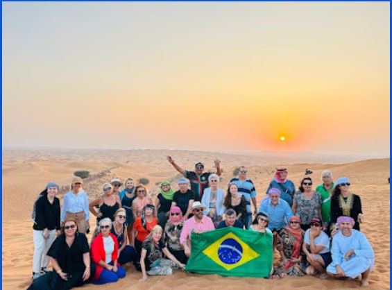 Grupo Rigue no deserto de Dubai com bandeira do Brasil