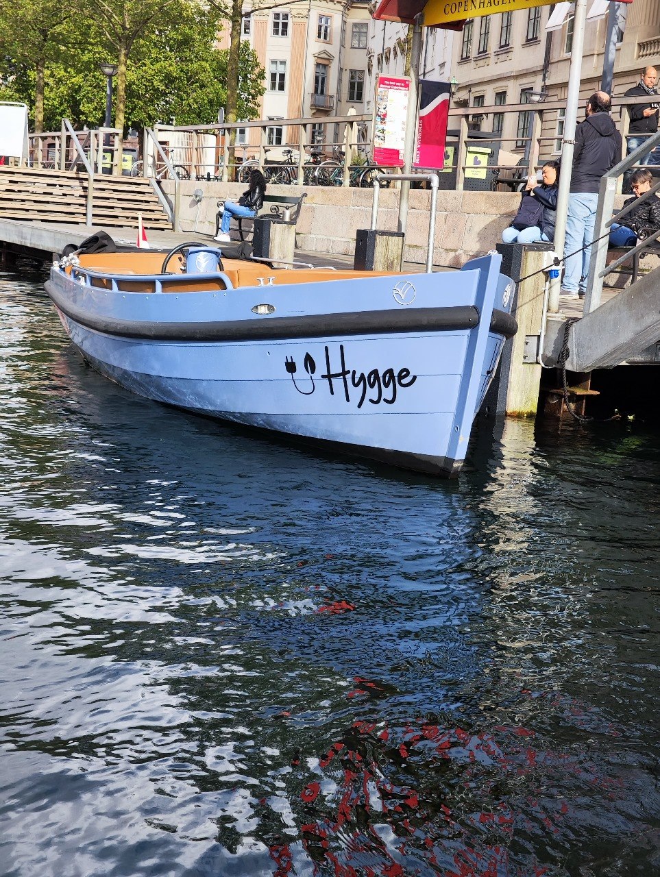 Barco com a palavra Hygge em um canal de Copenhagen, inspiração para o nome Rigue